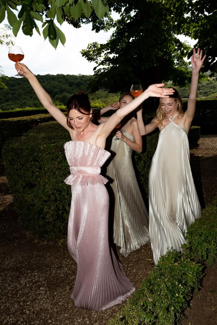 Invitadas con vestidos de fiesta brindando en un jardín